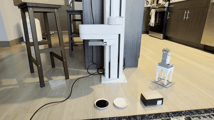 The PF400 picks up the pipette, transfers soy sauce between saucers, presses the ejector against a stool, and returns the pipette to its stand.
